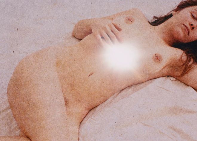 Una donna nuda distesa su un lenzuolo, con una macchia di luce sul ventre.